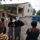 Residents stand looking at a collapsed school damaged bya magnitude 5.9 earthquake the night before, in Gros Morne, Haiti, Sunday, Oct. 7, 2018. Emergency teams worked to provide relief in Haiti on Sunday after the quake killed at least 11 people and left dozens injured.